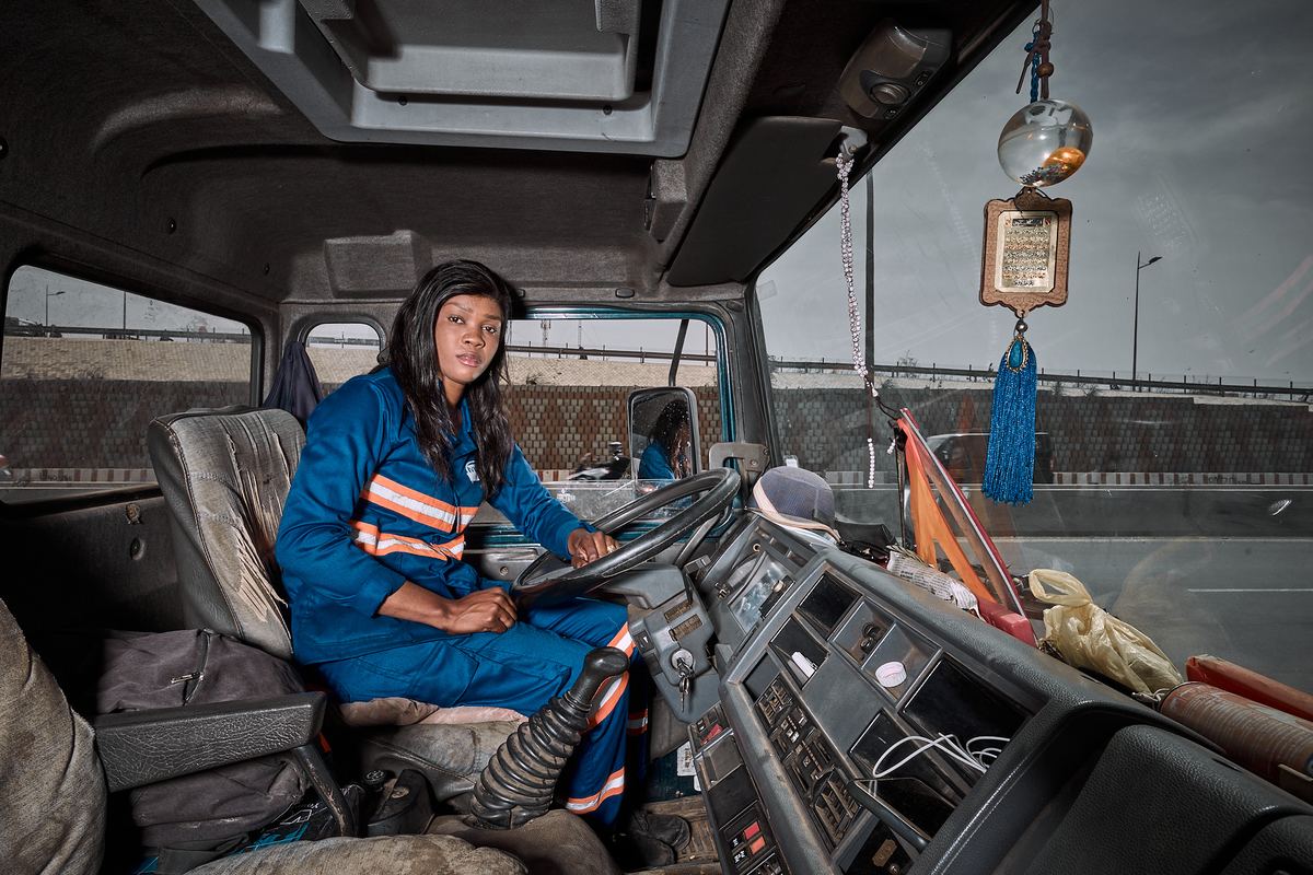 Conductrice en tenue de travail au volant d'un camion hydrocureur